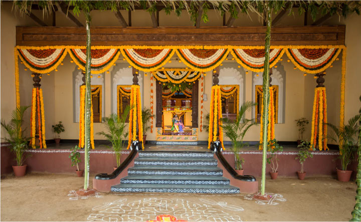 Village style wedding theme at Ramoji Film City Hyderabad with traditional floral decorations, clay pots, rangoli, and a rustic entrance setup.